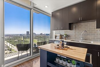 a kitchen with a island and a balcony with a city view